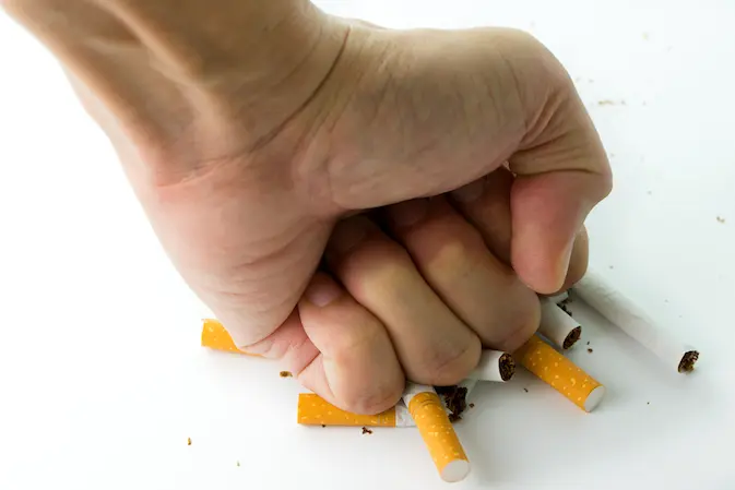 met vuist sigaretten platdrukken