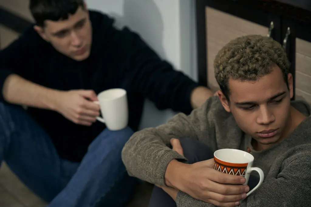 Twee jongens die koffie drinken, een probeert met de ander te praten